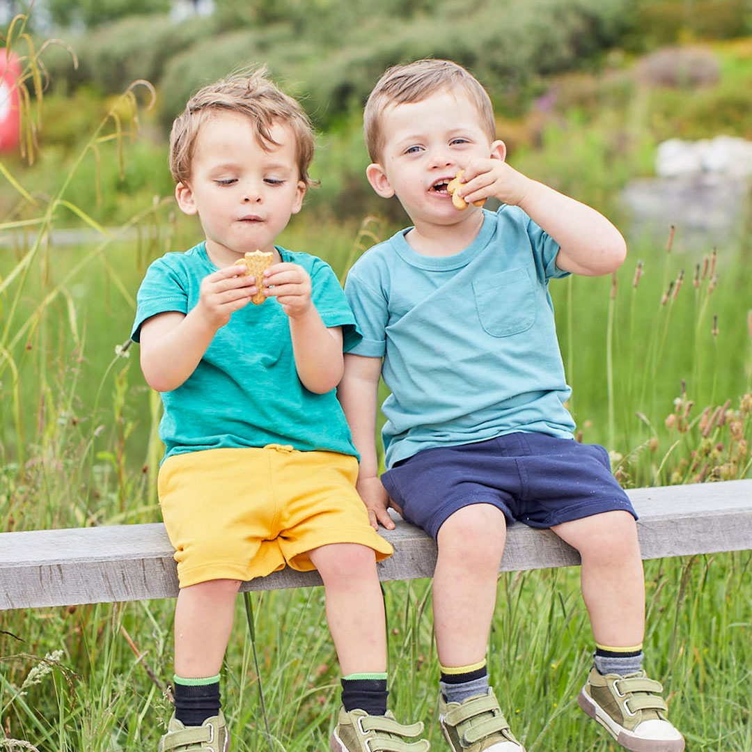 Two boys eating biscuits