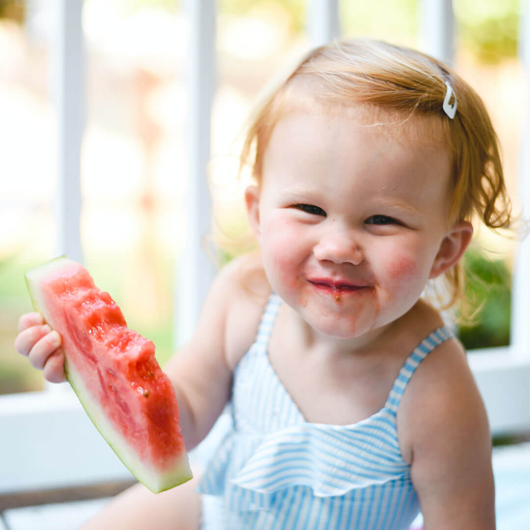 A toddler eating some fruit
