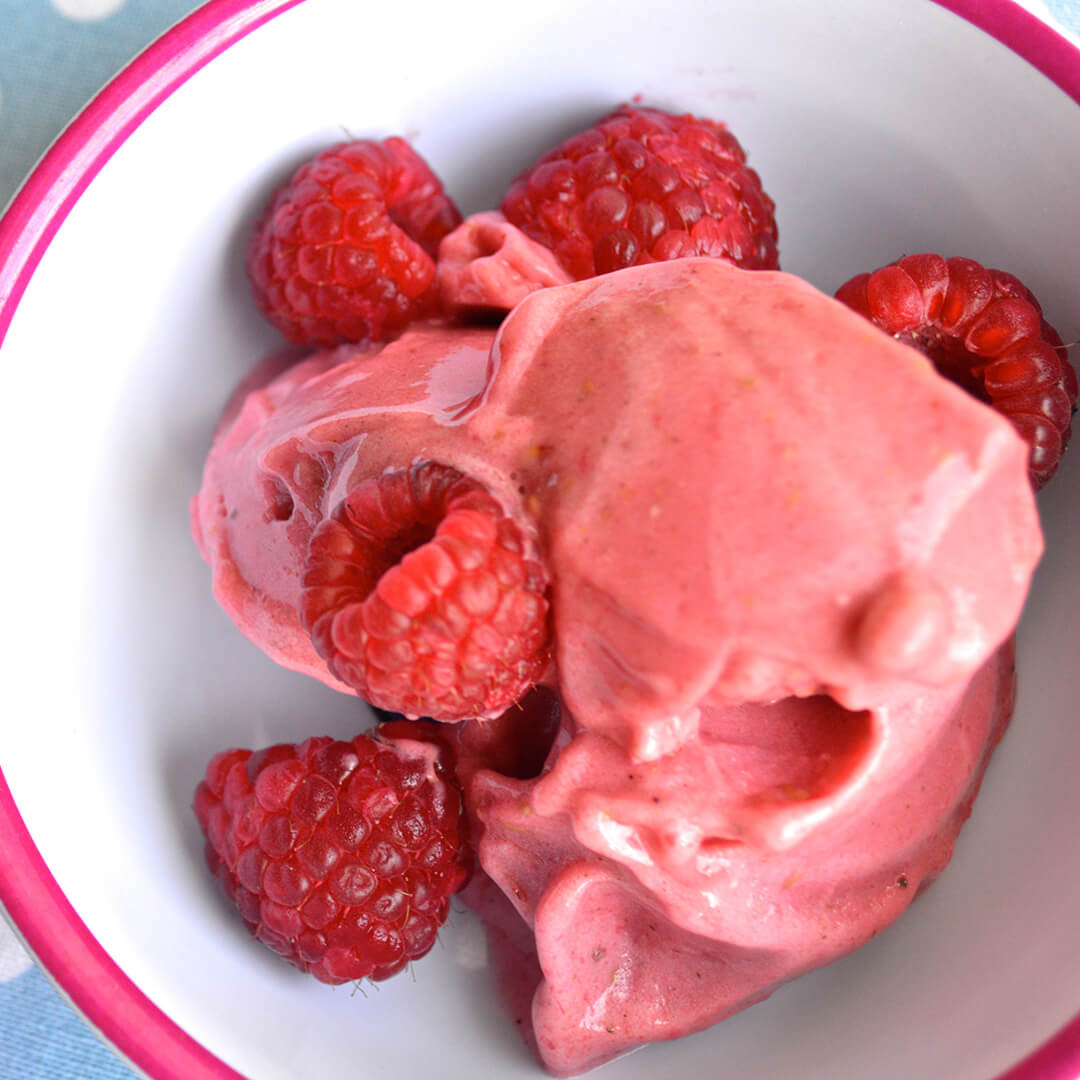 A bowl of Raspberry & Banana Sundae served with fresh raspberries