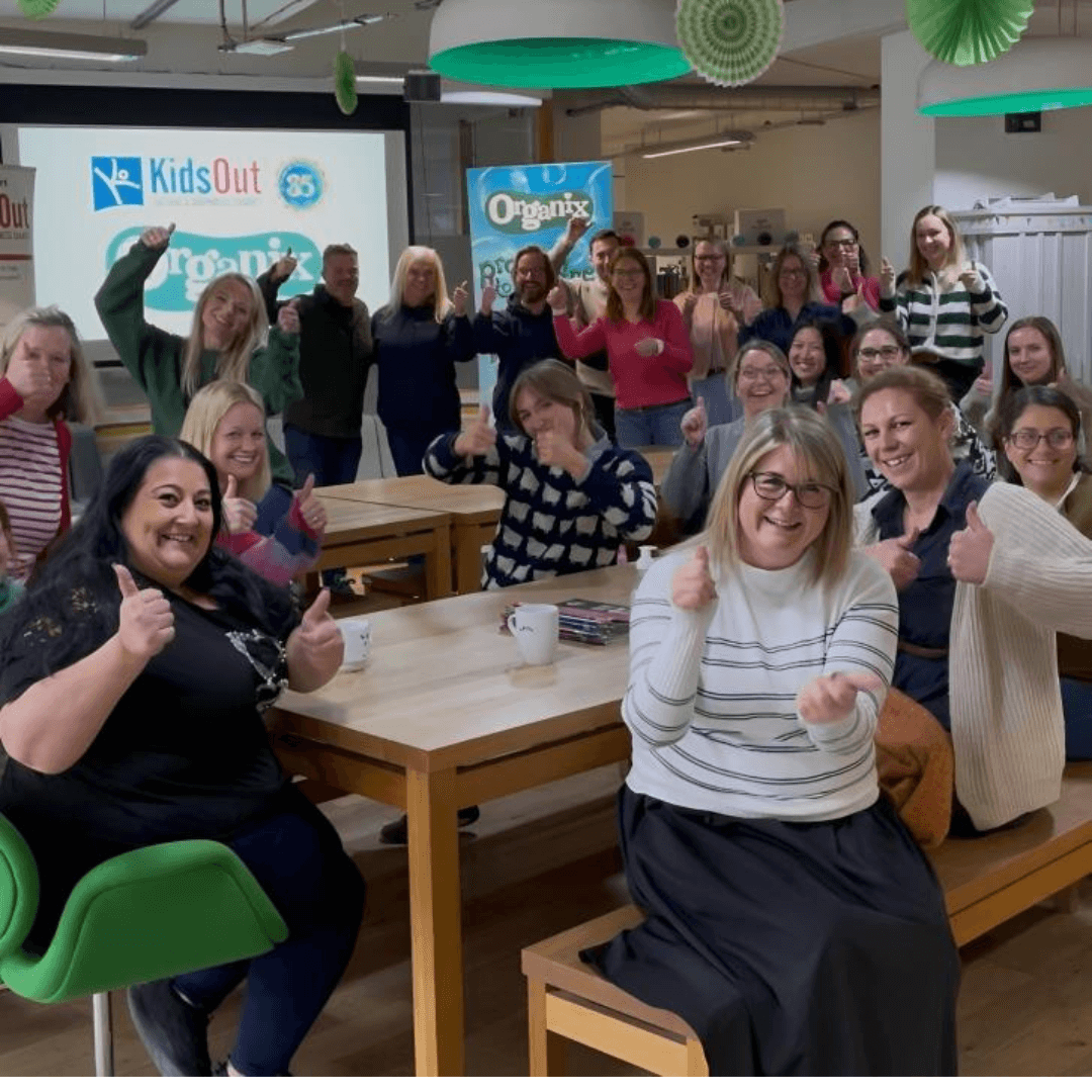Organix employees at their office, giving a thumbs up, during the internal launch of Organix Partnership with Kids Out